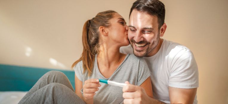 happy couple looking at pregnancy test