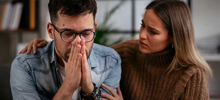 Stressed out male comforted by female partner