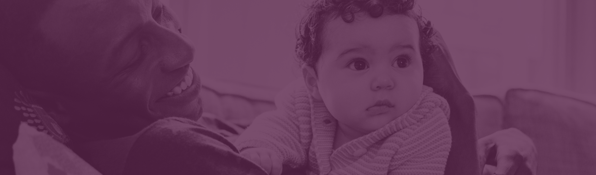 smiling father holding baby on a purple background