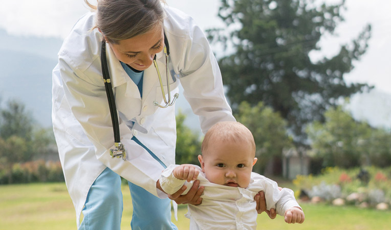 baby walking with doctor parent