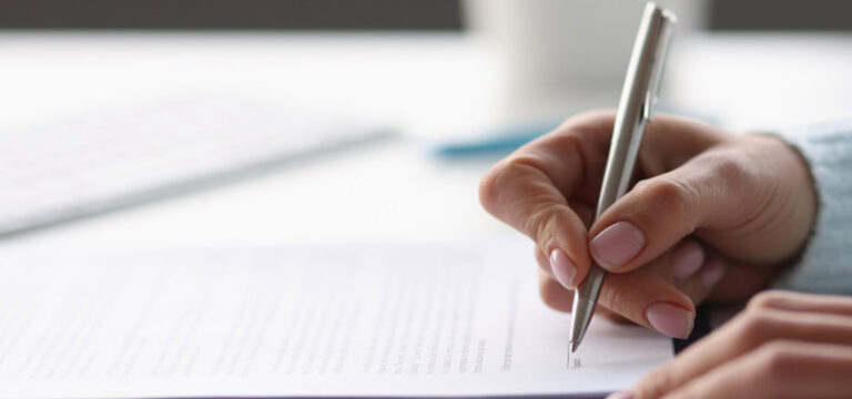 closeup of hand signing the Access to Family Building Benefits letter