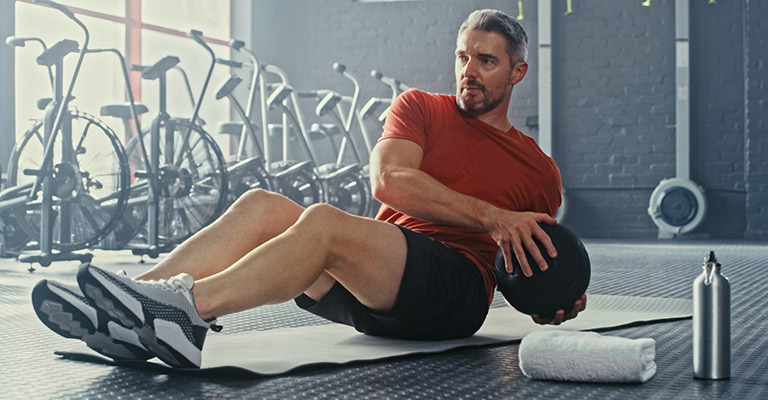 seated man exercising obliques with exercise ball