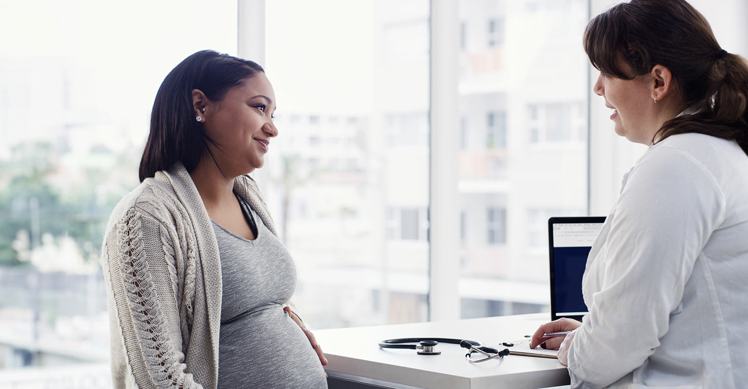 pregnant woman in her second trimester meeting with doctor