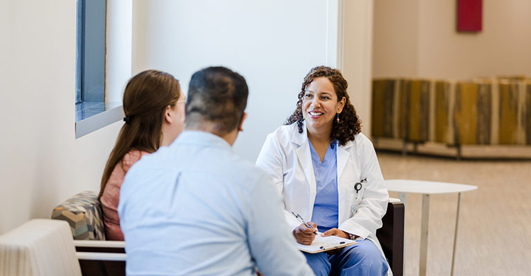 provider meeting with her patients in the hallway of a clinic