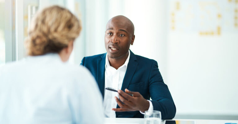 Two people in a meeting room having a discussion