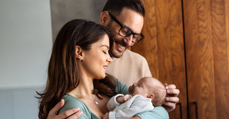 smiling couple looking at baby