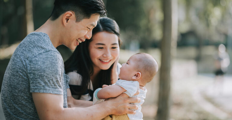 Young couple outdoors with a baby