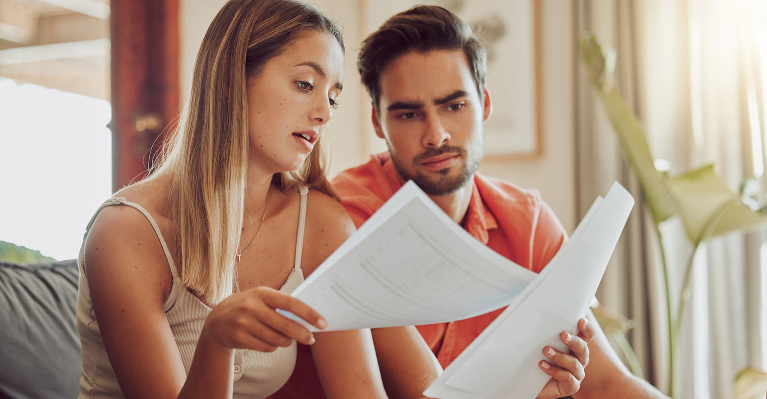 seated couple reviewing paperwork