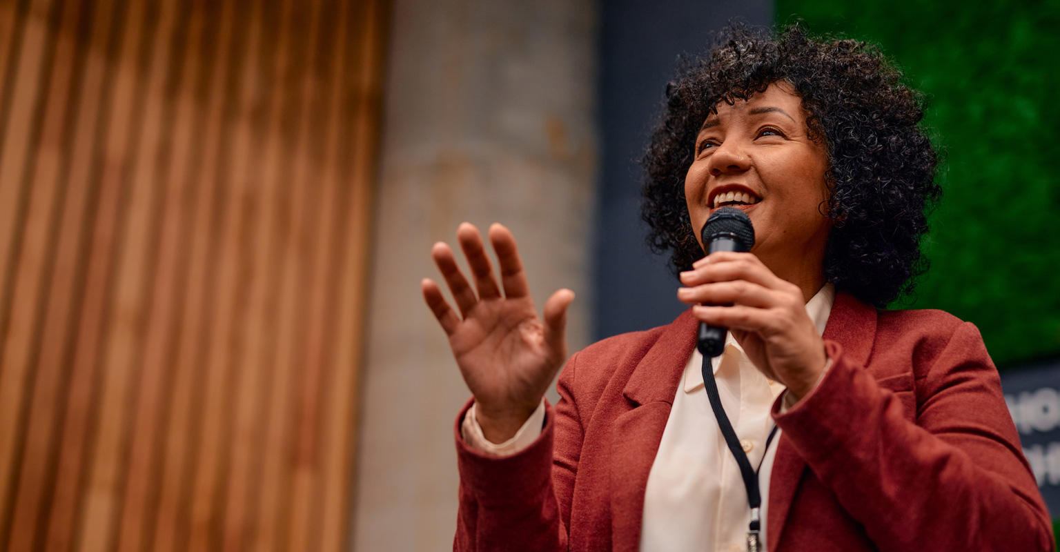 woman speaking in a microphone facing the side
