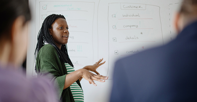 a pregnant woman presenting at whiteboard