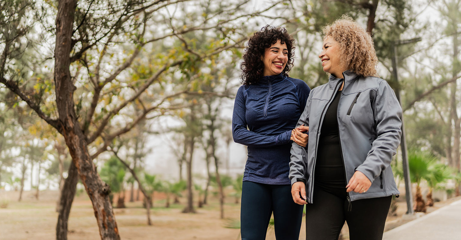 two women walking through the park