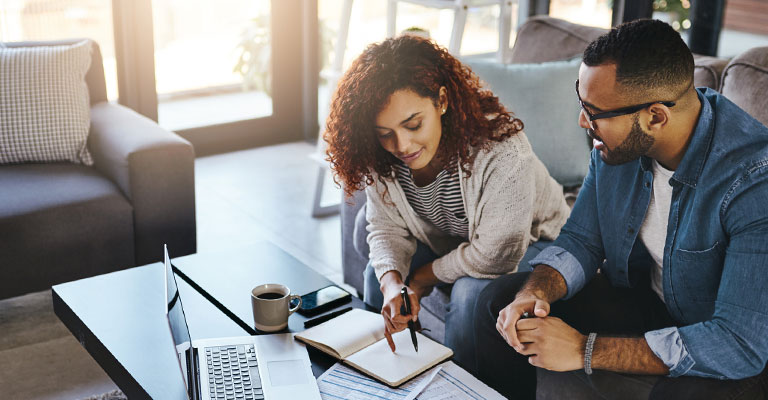 seated couple reviewing something on their laptop
