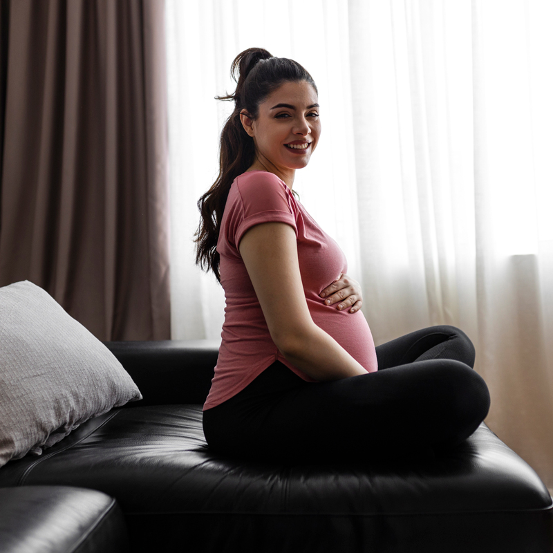 seated pregnant woman smiling at camera