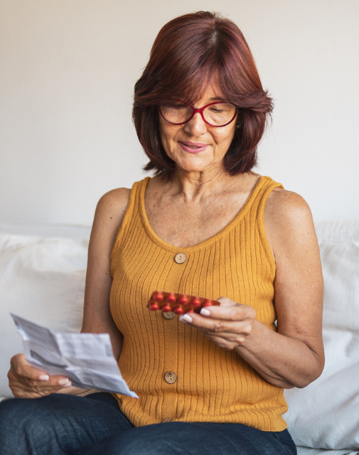 woman in midlife looking at medications