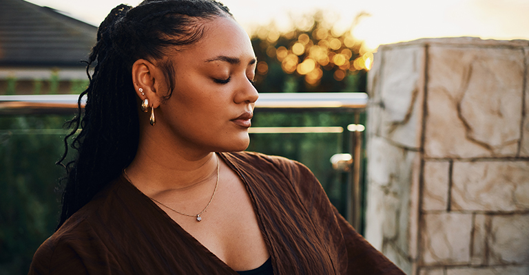 seated woman with her eyes closed meditating