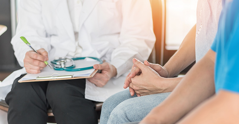 doctor seated with patients, no faces shown